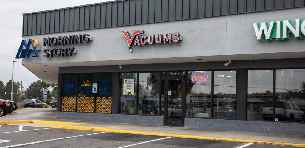 Gray building with a sign for a restaurant and a Vacuum store