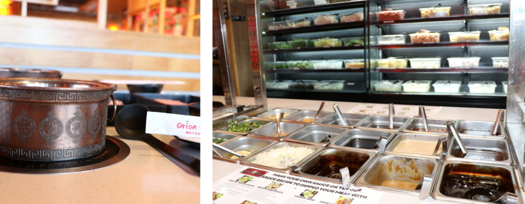Black cast iron pot on a small stove and rows of sauces with soup ingredients behind