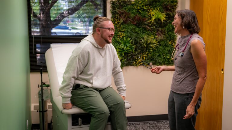 Patient talking with doctor in a medical office with floral wall