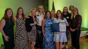 A group of people smiling with an award